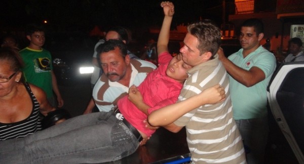 Júnior Carneiro (camisa de listra) carregando a esposa para levar ao hospital